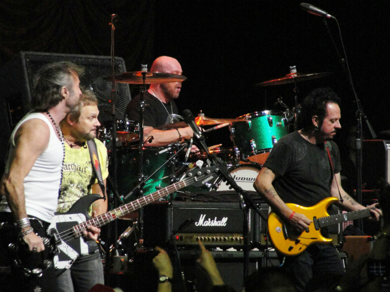 A group of men playing guitars on stage.