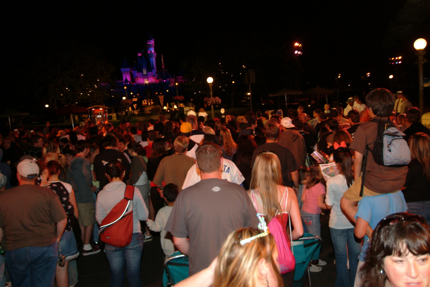 A crowd of people standing around at night.