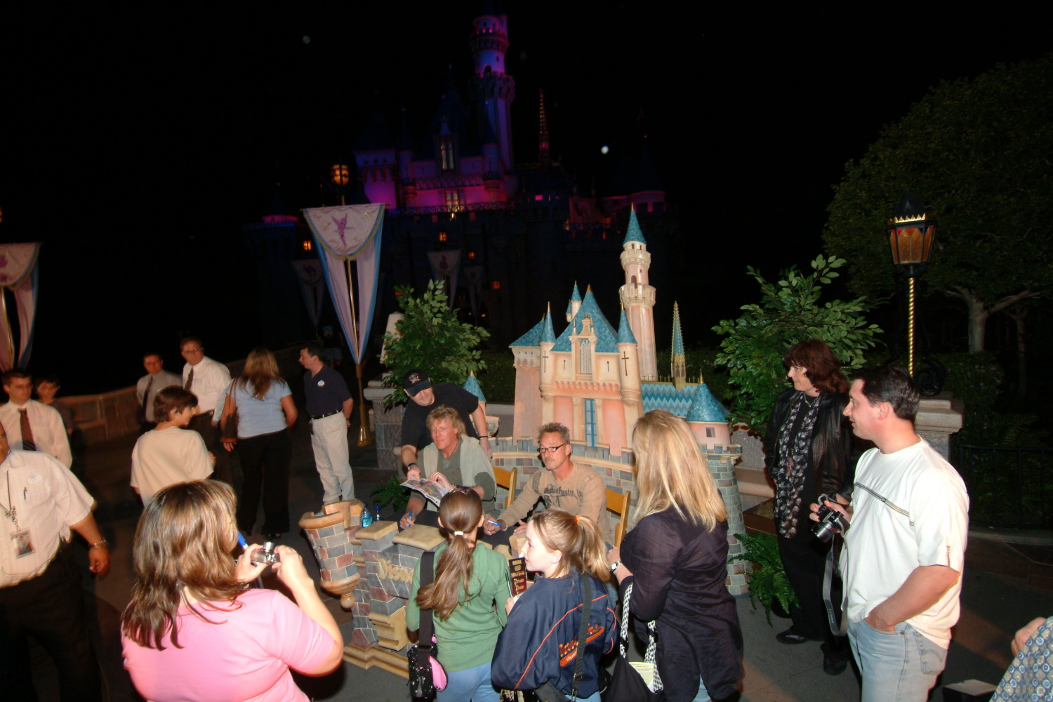 A crowd of people standing around at night.