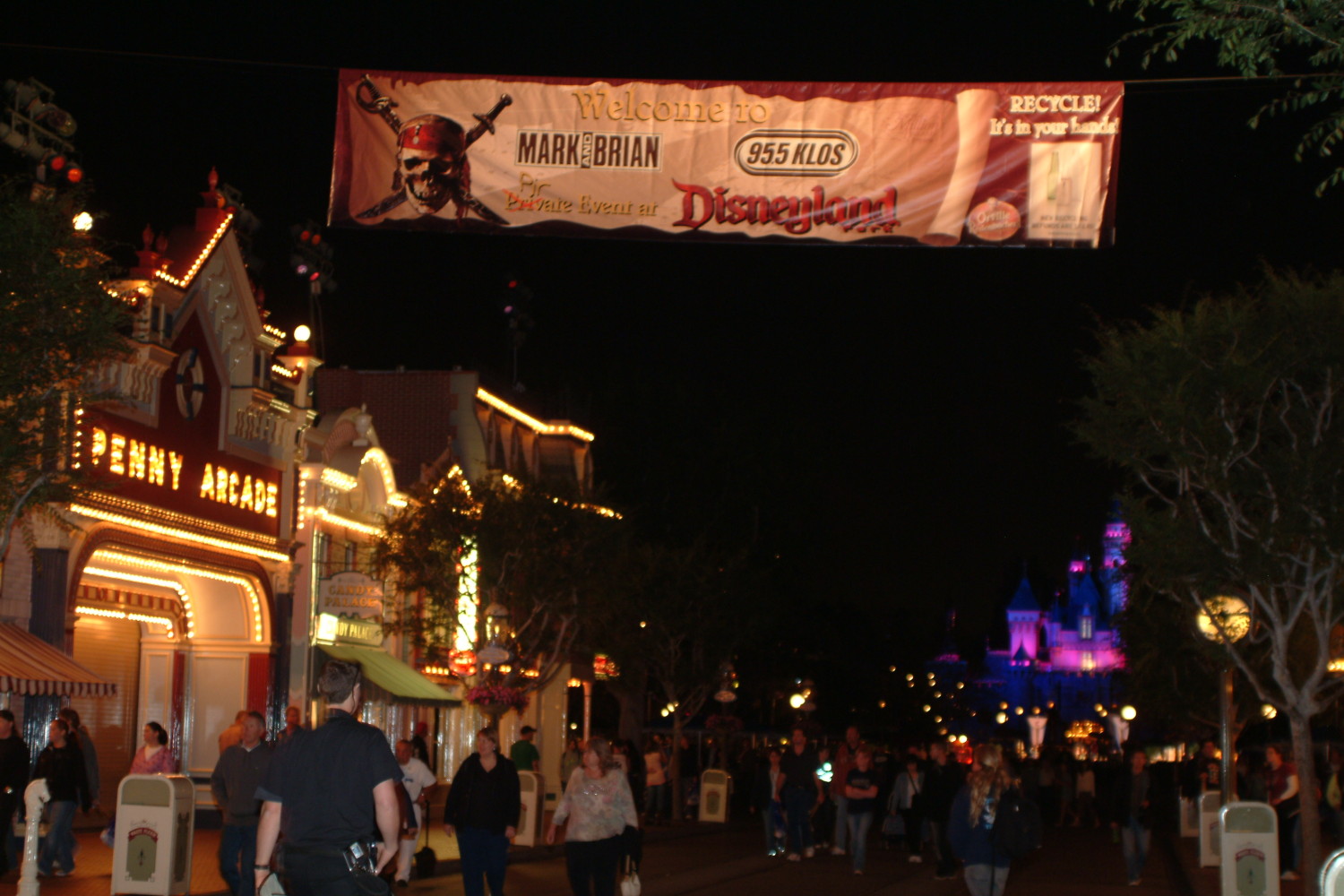 A crowd of people walking down the street at night.