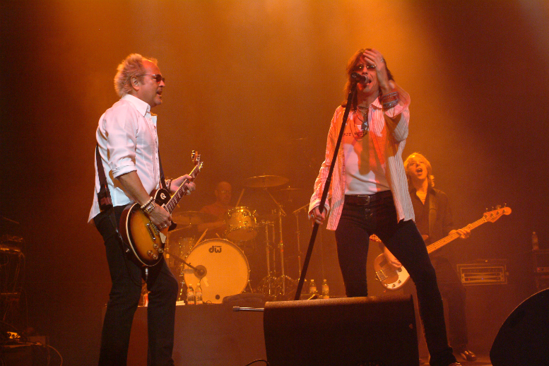 A man on stage with a guitar.