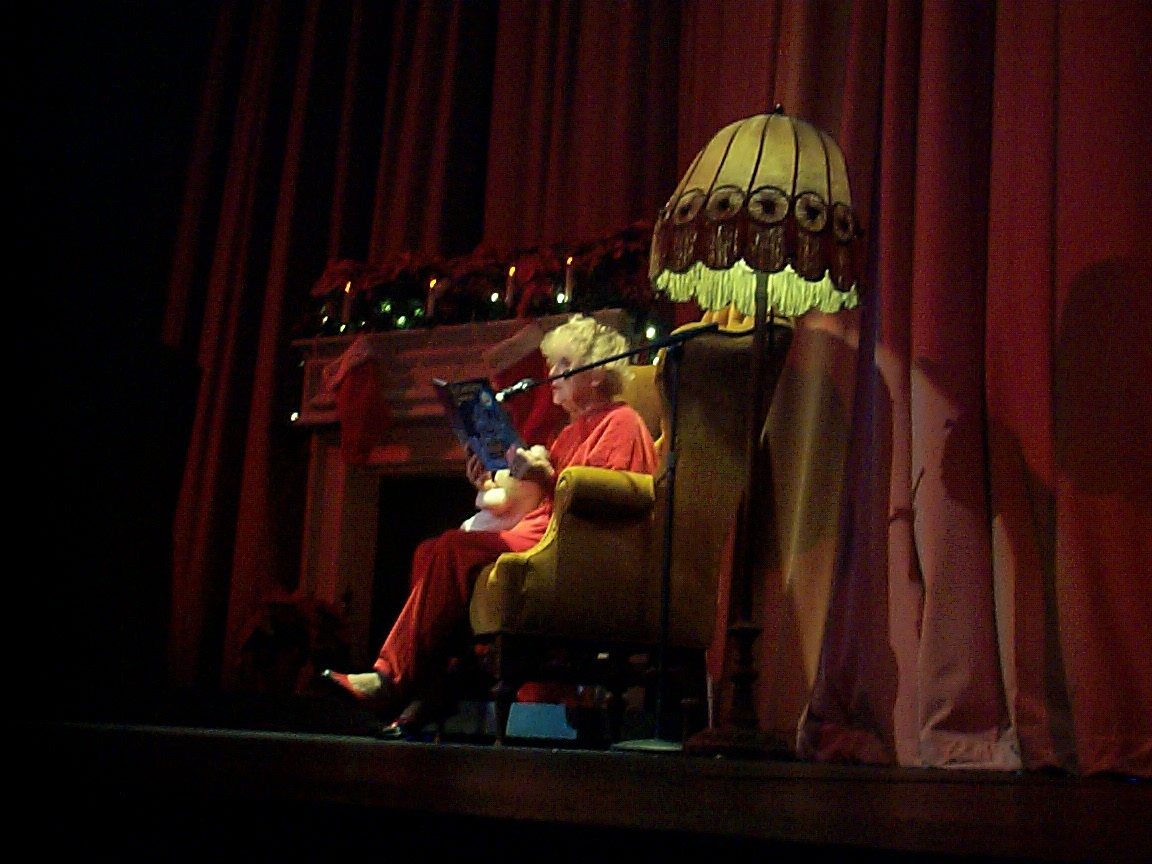 A woman sitting in a chair reading a book.