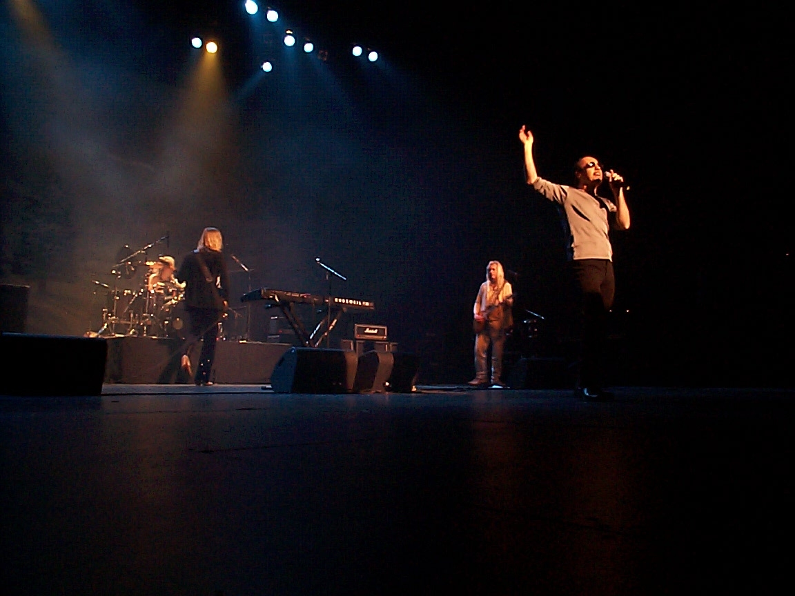 A group of people on stage with their hands raised in the air.