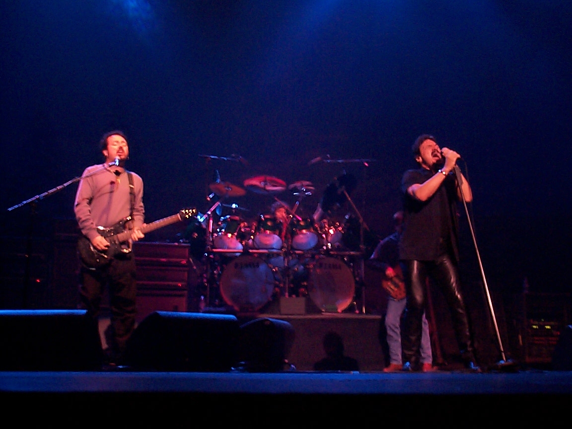 A group of men standing on stage with microphones.