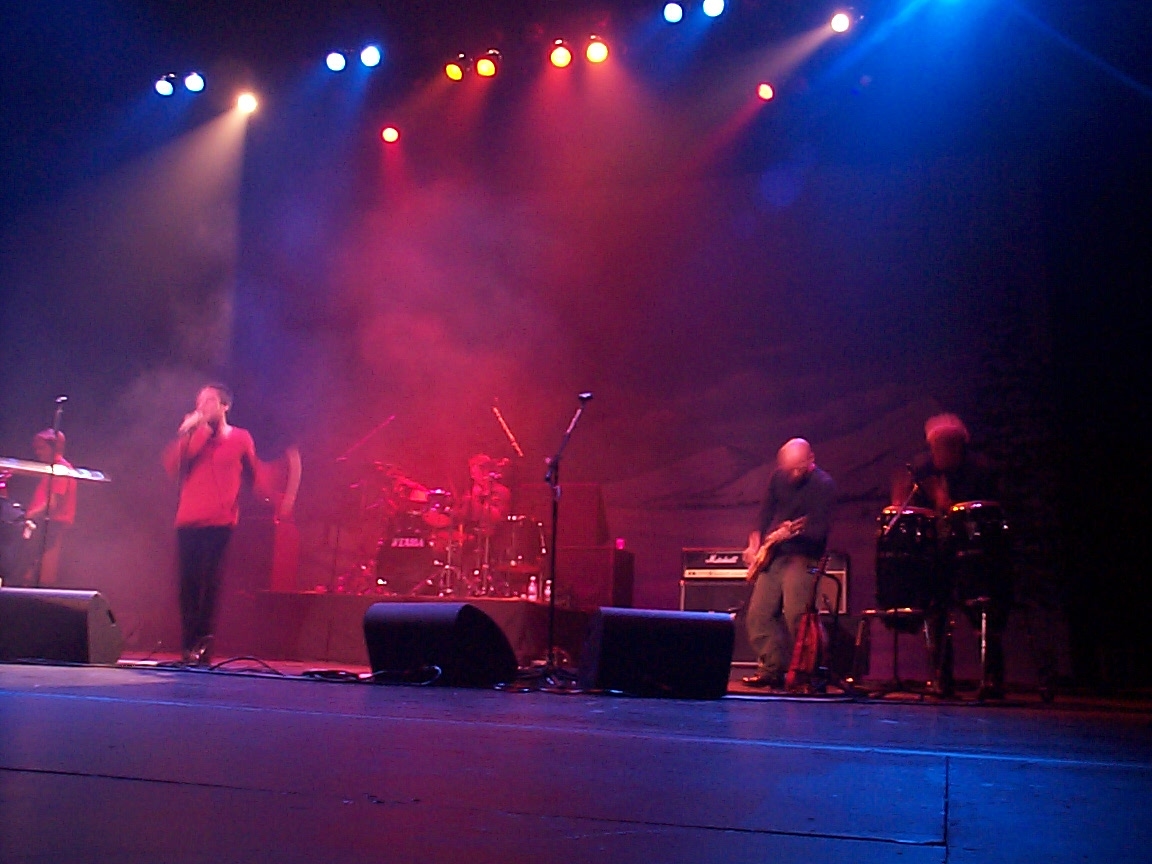 A group of people on stage in a concert.