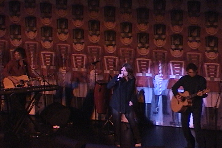A group of people on stage with guitars and microphones.