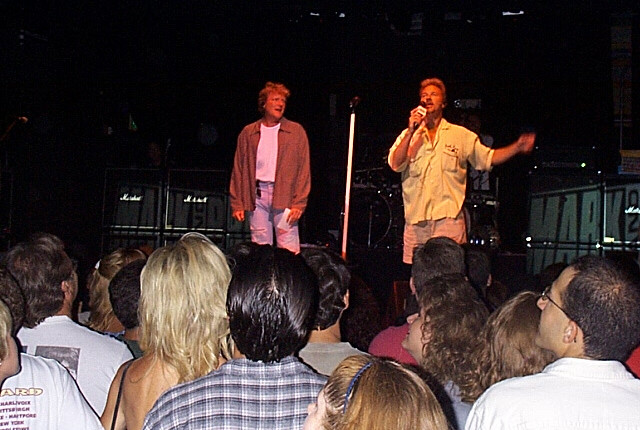 Two men standing in front of a crowd of people.