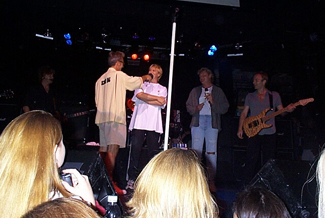 A group of people standing on stage with a microphone.