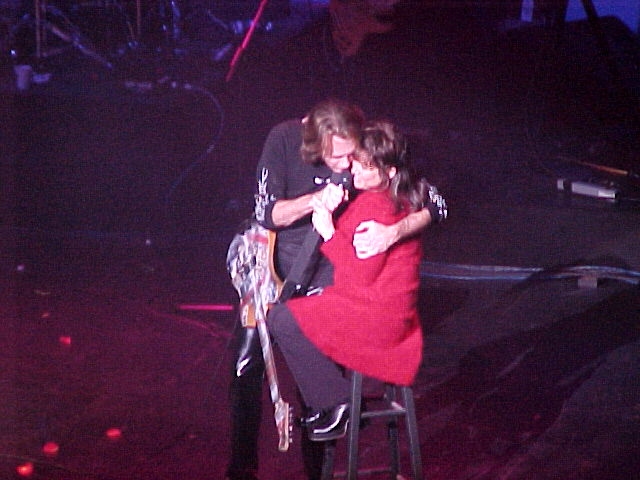 A man and a woman hugging on stage.