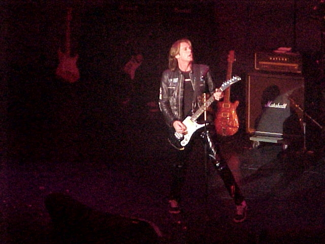 A man playing a guitar on stage.