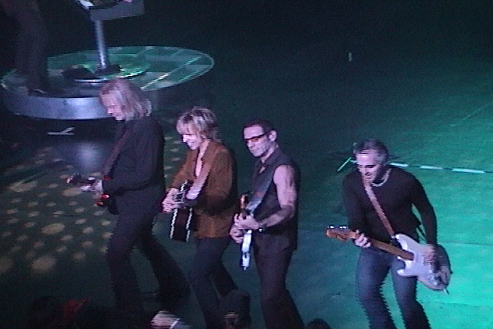 A group of people standing on stage with guitars.