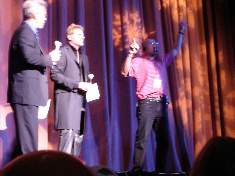 Three men standing on stage.