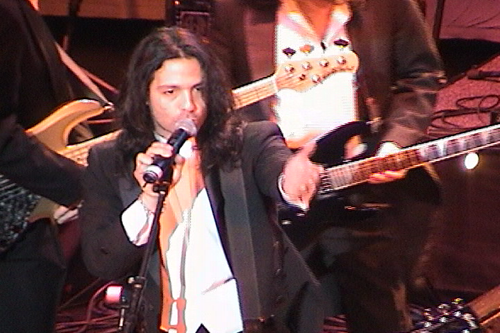 A man in a suit singing into a microphone.