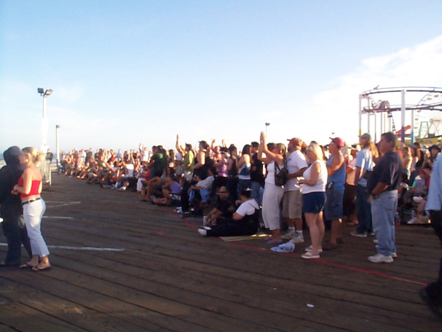 A crowd of people standing on a pier.