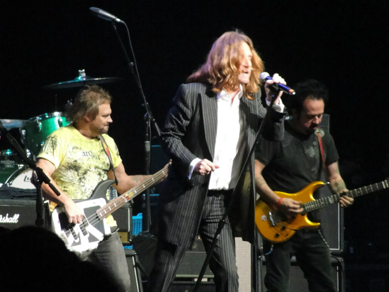 A man in a suit singing into a microphone.