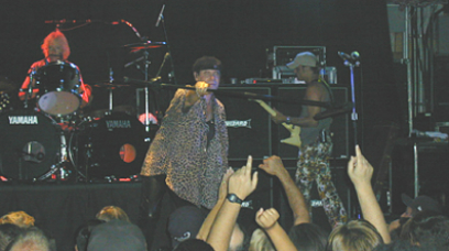 A group of people are on stage at a concert.