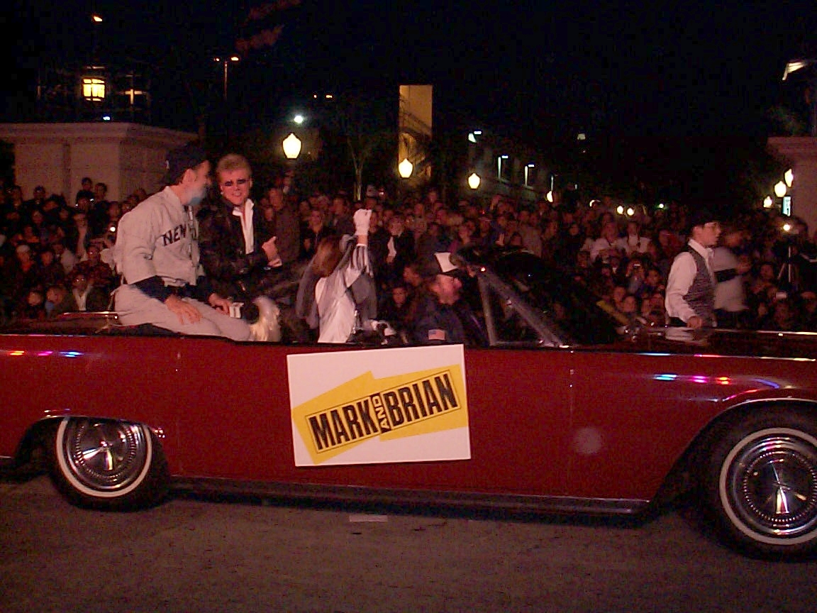 A group of people in a car on the street.