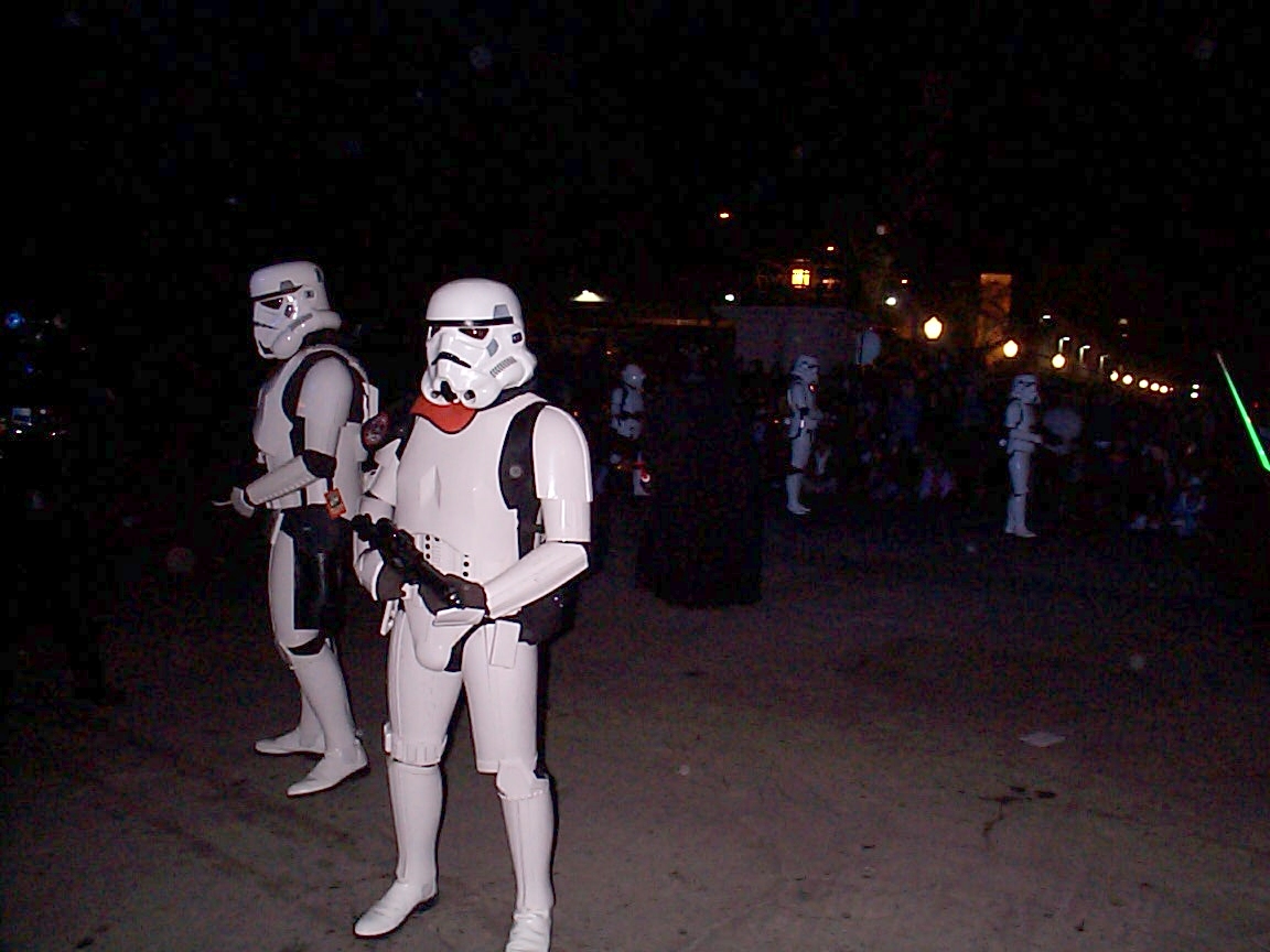 Two people dressed as storm troopers in a dark area.