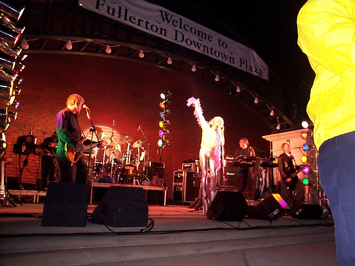 A band performing on stage at night with lights.