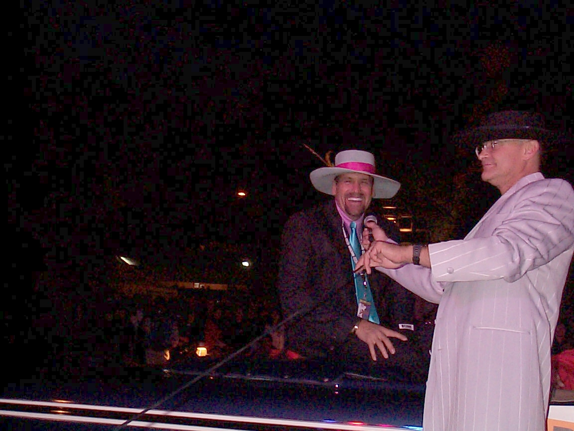 A man in a hat and a suit is standing on stage