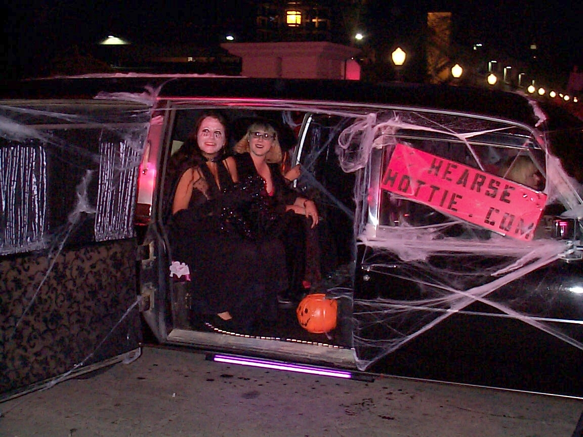 Two women in a limo with halloween decorations.