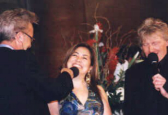 A woman singing into a microphone at an event.