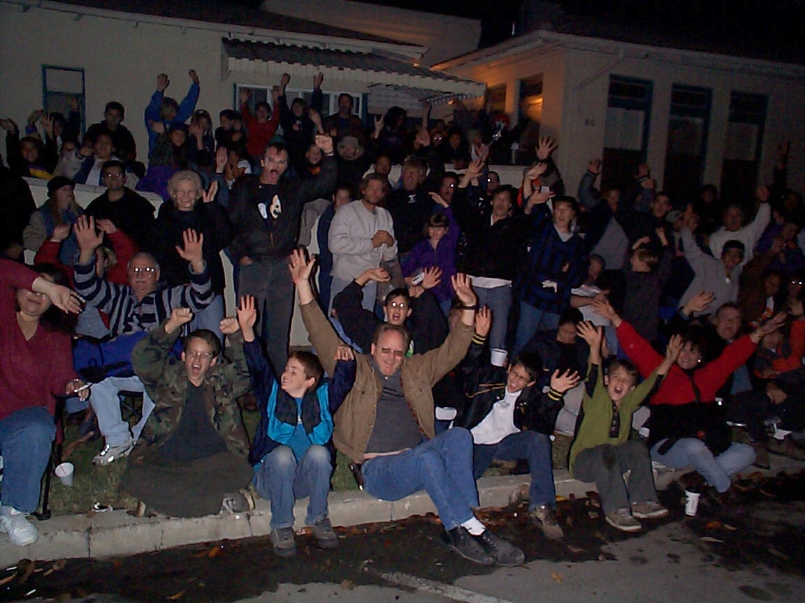 A group of people sitting on steps in front of a building.