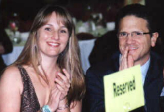 A woman and man smile for the camera.