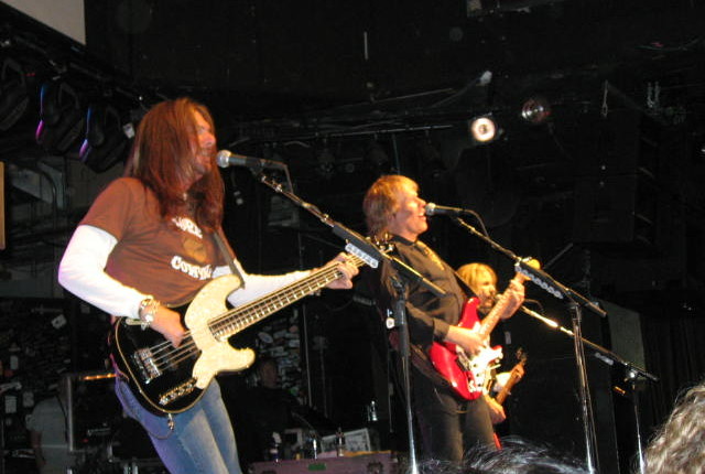 A group of people playing guitar on stage.