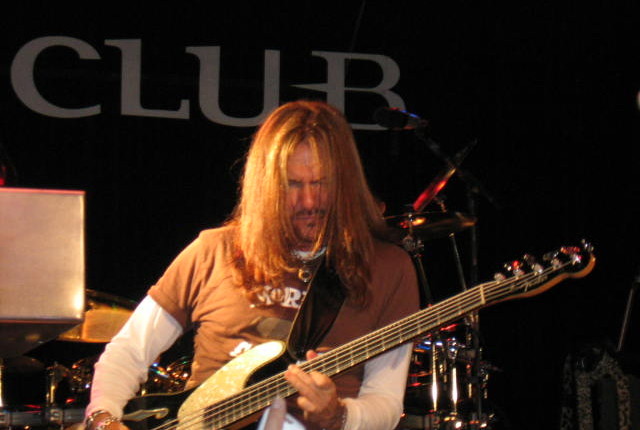 A man playing an electric guitar on stage.