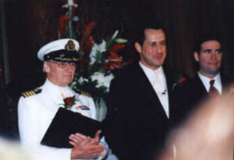 Two men in suits and hats standing next to each other.