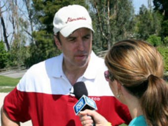 A man in red and white shirt being interviewed by a woman.