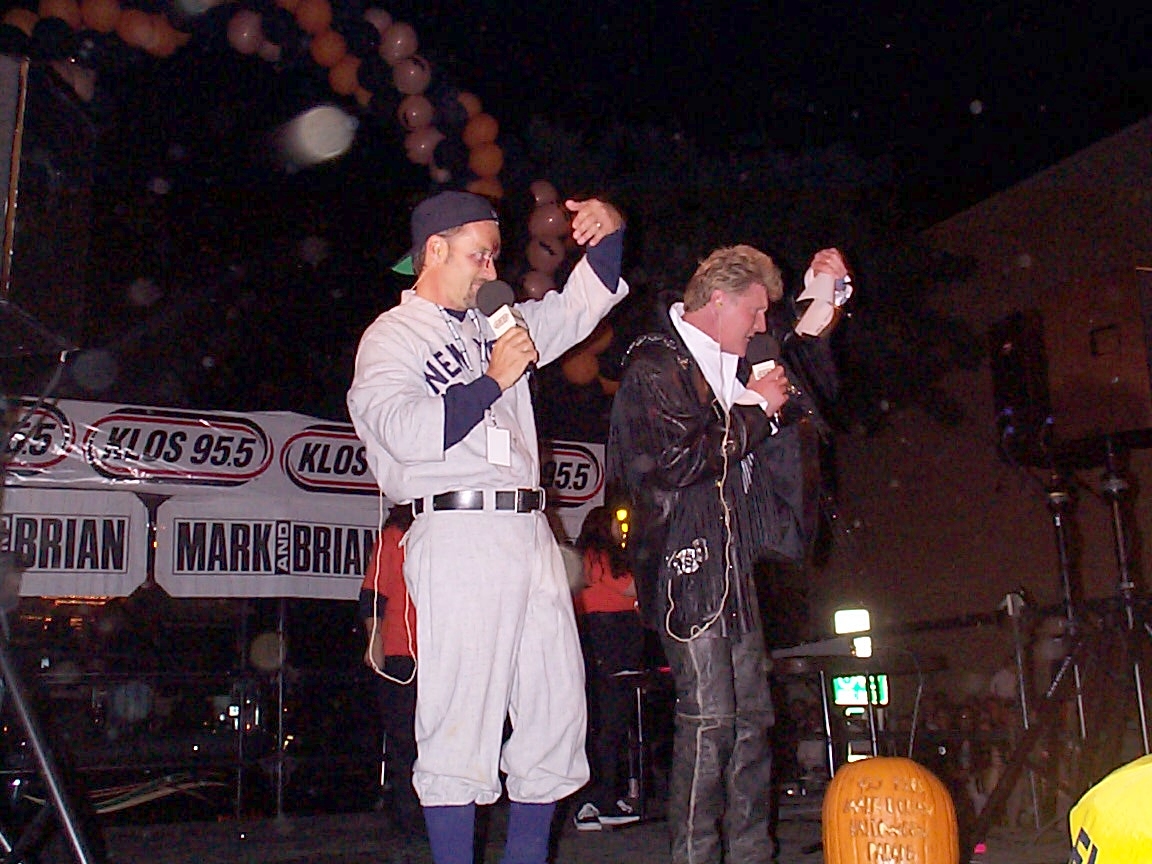 A man and a woman standing on stage with microphones.
