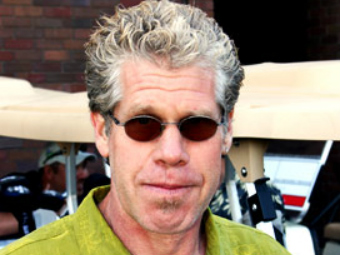 A man with sunglasses on his head and wearing a green shirt.