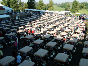 A large group of tables and chairs in the middle of an outdoor event.
