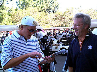 Two men are standing in a parking lot.