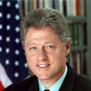A picture of bill clinton in front of an american flag.