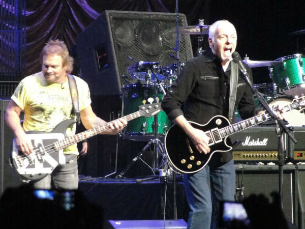 A man and woman playing guitar on stage.