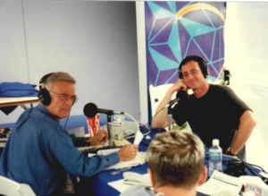 A group of people sitting at tables with microphones.